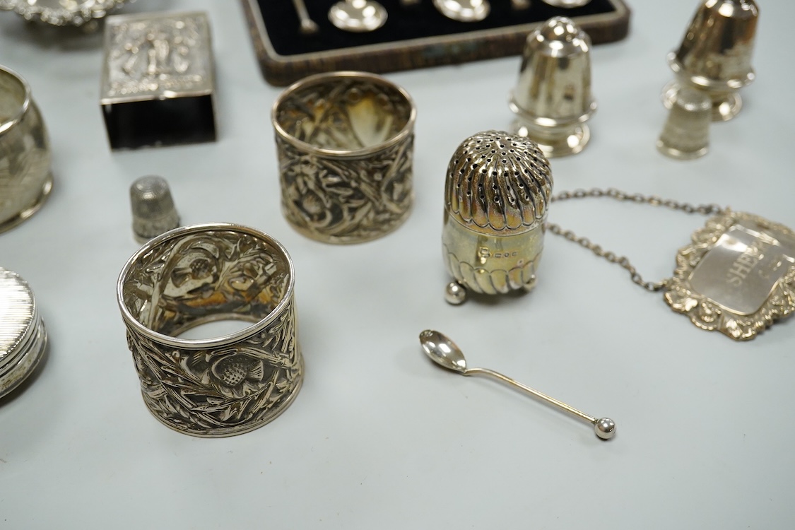 A collection silver and white metal to include a cased set of six George V seal top coffee spoons, Birmingham, 1927, a pair of Scottish napkin rings embossed with thistles, a pair of embossed heart shaped bonbon dishes,